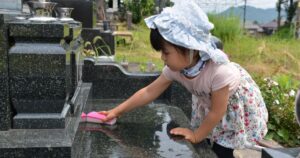 墓石を掃除する女の子